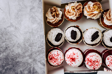 Variety of delicious cupcakes presented in a white box with copy space. Red Velvet cupcake, dark...