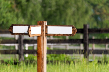 Empty wooden sign with arrows on the ranch. Simple wooden triple direction arrow roadsign.