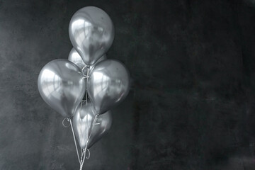 Silver gray balls on the background of gray walls from large ceramic tiles with copy space