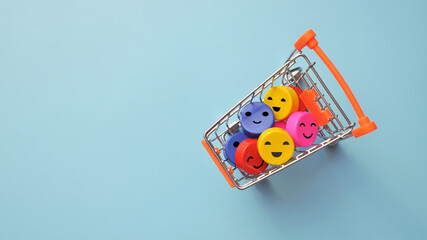 A shopping cart and colorful crudes with a smile inside. A symbol of happy shopping