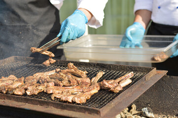 Blurred image of a chef who grills a lamb. Street diner.