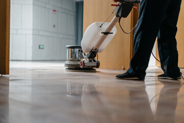 worker is cleaning floor with machine