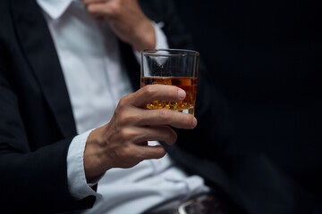 Man wearing a suit whiskey glass of liquor 