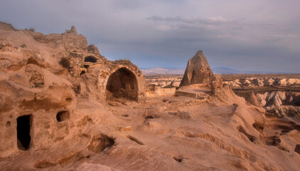 Fototapeta premium Ancient city of Uchisar with residential dwellings in caves, Cappadocia Turkey on sunset
