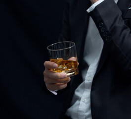 Man wearing a suit whiskey glass of liquor 