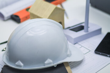 Engineers and architects' desk filled with blueprints, stationery and Equipment, a lot of documents and a helmet placed on the desk To prepare for the meeting of the foreman-engineer team