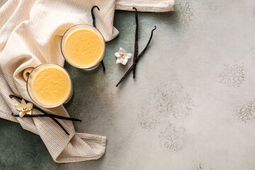 Glass bowls with tasty vanilla pudding on grunge background