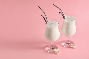 Glasses with tasty vanilla milkshake on color background