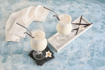 Obraz na płótnie Canvas Glasses with tasty vanilla milkshake on color background