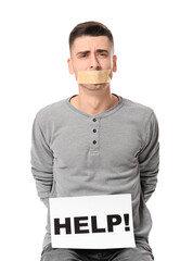 Male hostage and paper with word HELP on white background