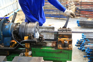 Craftsmen turning deformed threads at a construction site.