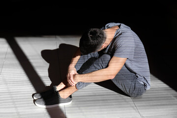 Male hostage sitting on floor in room