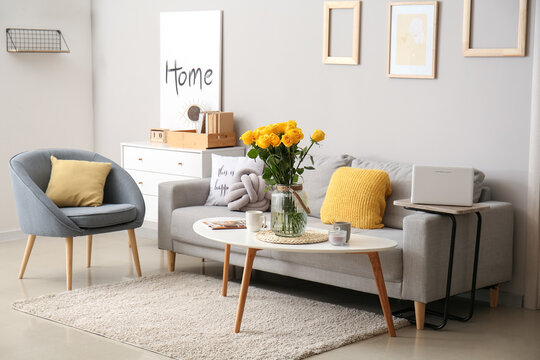 Interior of stylish living room with vase and yellow roses