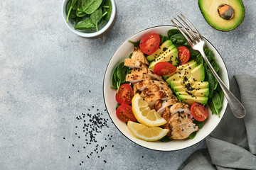 Fresh green salad with grilled chicken fillet, spinach, tomatoes, avocado, lemon and black sesame...