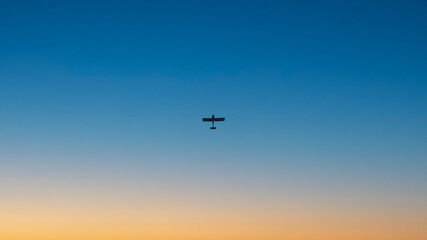 Fototapeta na wymiar Airplane on the background of a clear blue sky at sunset