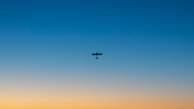 Airplane on the background of a clear blue sky at sunset