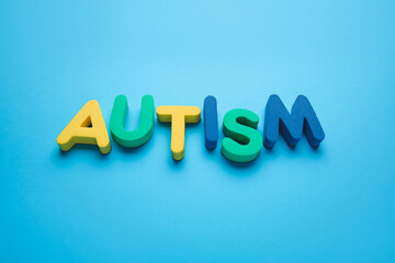 Word AUTISM on color background