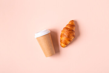 Coffee to go in a paper cup with croissants.