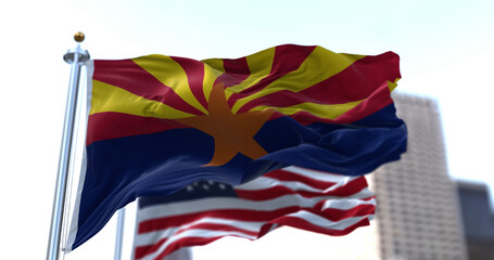 The flags of the Arizona state and United States waving in the wind