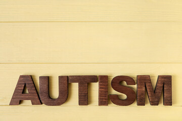 Word AUTISM on color wooden background