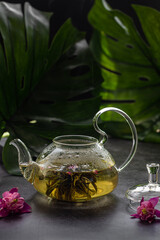 Exotic green tea with flowers in glass teapot