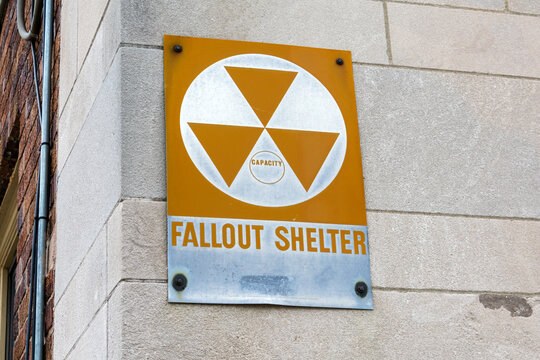 Fallout Shelter sign informs about nearby enclosed space specially designated to protect occupants from radioactive debris or fallout resulting from a nuclear explosion.