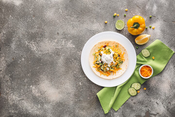 Fototapeta na wymiar Plate with tasty taco and sauce on grunge background