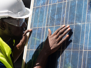 Professional electrical engineers in a safety helmet and uniform checking photovoltaic solar panels for maintenance, professional engineer concept about solar cell system.