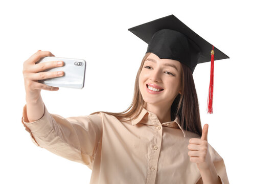 Happy female graduating student taking selfie on white background