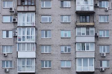 facade of a gray communist house with balconies and air conditioning
