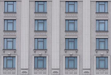 building facade with gray walls and decor between windows
