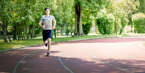 Young man jogging in the morning out on the race track.