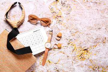 Calendar and female accessories on grunge background