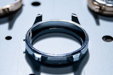Close up of shiny stainless steel watch case warm up inside vapor deposition machine, PVD coating...
