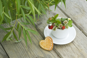 white cup with clover and strawberries, heart-shaped cookies