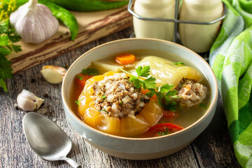 Healthy food, keto diet, lunch. Bell pepper with meat and bulgur in a broth with vegetables in a bowl on a rustic table.