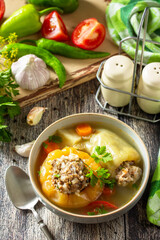 Healthy food, keto diet, lunch. Bell pepper with meat and bulgur in a broth with vegetables in a bowl on a rustic table.