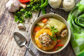 Healthy food, keto diet, lunch. Bell pepper with meat and bulgur in a broth with vegetables in a bowl on a rustic table. Top view flat lay background.