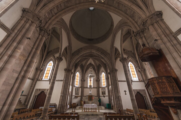 Obraz premium Interiors and details of the Cathedral of Angangueo, Michoacán, Mexico, you can see symmetry in its columns of a Gothic style, the wooden details such as its benches and the pulpit.