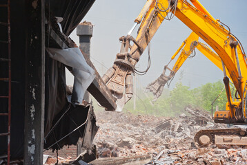 Two demolators destroy the building and remove the debris.