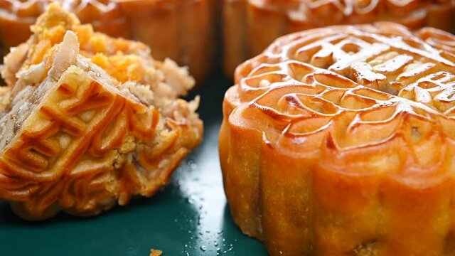 translation of the Chinese to English-five kernels-angle view round shape traditional mooncakes with one piece cut out rotating