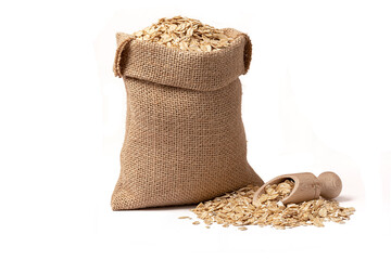 oat grains with husk in burlap bag with wooden scoop full of oatmeal near isolated on white...