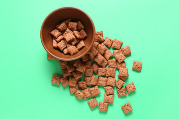 Bowl with tasty corn pillows on color background