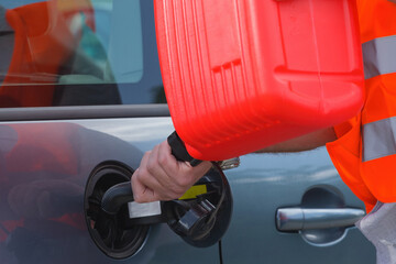 Driver fills the fuel in an empty car tank from canister.