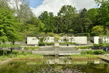 Fototapeta na wymiar L'une des pièces d'eau entourée de décoration paysagère idyllique aux Jardins du Fleuriste à Laeken