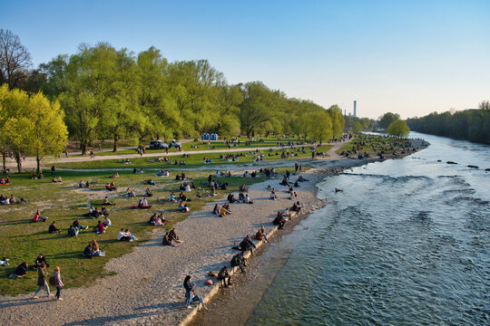 Isar M&uuml;nchen mit Menschen in der Sonne bei der Reichenbachbr&uuml;cke / Kirche St. Maximilian