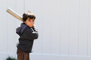 Young Brown Haired Boy Holding Bat Against White Background