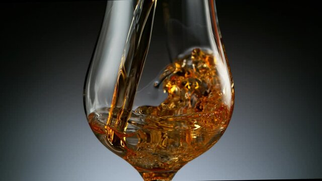 Super slow motion of pouring cognac into glass, speed ramp effect. Filmed on high speed cinema camera, 1000 fps.