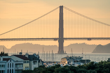 Obraz premium The Golden Gate Bridge on the background of a yellow sunset. San Francisco, California. USA