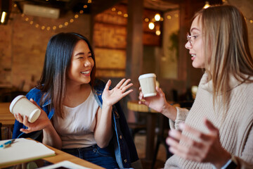 Positive Asian woman and pensive girlfriend